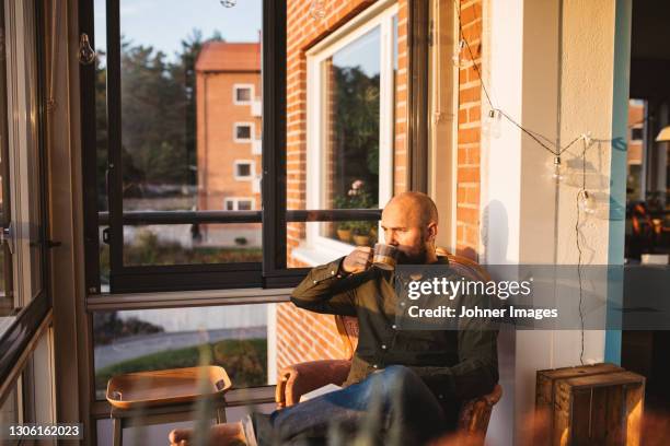 man having coffee on balcony - morning coffee stock pictures, royalty-free photos & images