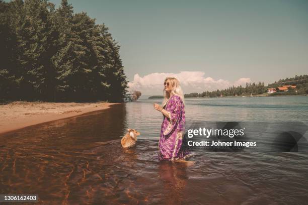 woman with dog walking in water - robe stock pictures, royalty-free photos & images