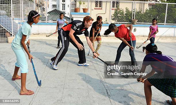 Jonathan Bairstow of England plays hockey with young girls during a team visit to Future Hope School on October 27, 2011 in Kolkata, India. The...