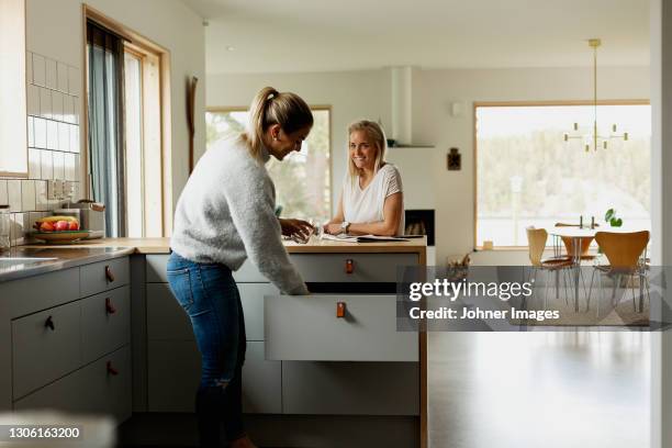 two women at kitchen counter - nordische länder europas stock-fotos und bilder