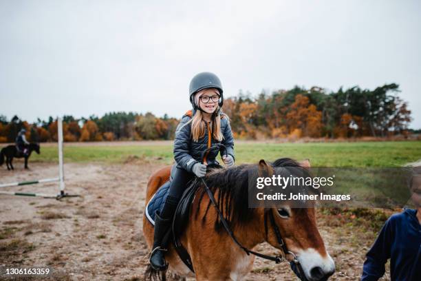 smiling girl riding pony - pony paard stockfoto's en -beelden