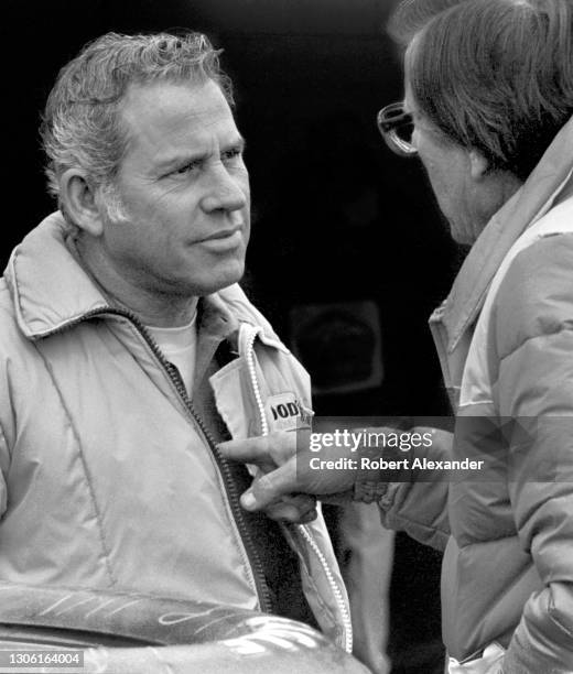 Driver David Pearson, left, talks with NASCAR car owner Bud Moore in the speedway garage prior to the start of the 1983 Daytona 500 stock car race at...