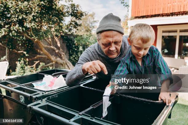 father and son recycling waste in garden - generation gap stock-fotos und bilder