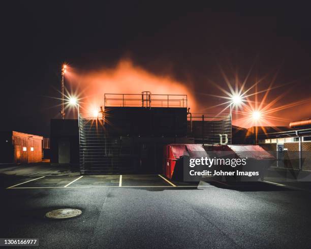 large garbage containers at night - parking space stock-fotos und bilder