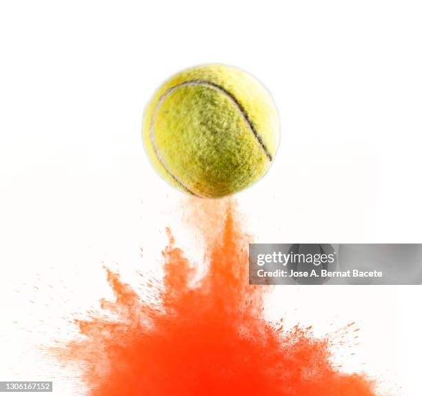impact and rebound of a ball of tennis on a surface of land and powder on a white background - balle de tennis photos et images de collection