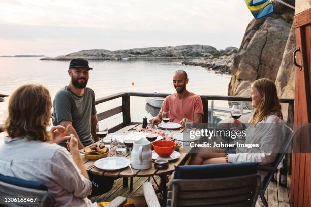 friends having meal on patio - four people foto e immagini stock
