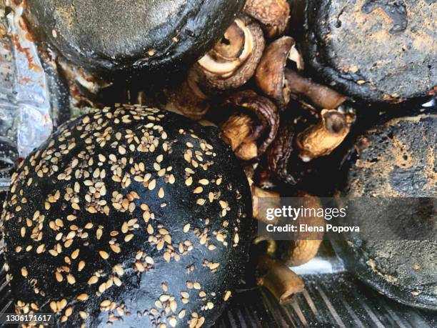 full frame grilled mushrooms and black hamburger buns with sesame seeds - close up bread roll black backdrop horizontal stock pictures, royalty-free photos & images