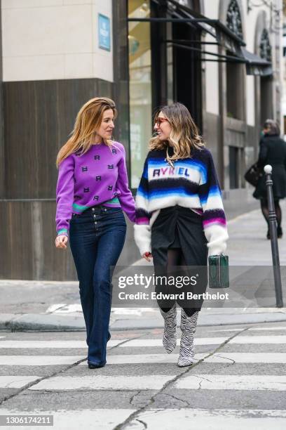 Ines Chicheportiche wears a purple wool pullover with printed letters "R" and green stripes from Sonia Rykiel, navy blue flared jeans from Sonia...