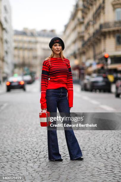 Ines Chicheportiche wears a black and red wool beret hat from Sonia Rykiel, a black and red striped pullover with long oversized sleeves from Sonia...