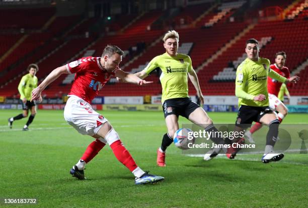 Chris Gunter of Charlton Athletic shoots as Ryan Watson of Northampton Town looks on during the Sky Bet League One match between Charlton Athletic...