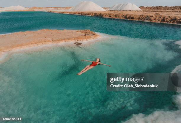 frau schwimmt im salzsee in siwa-oase - egypt stock-fotos und bilder