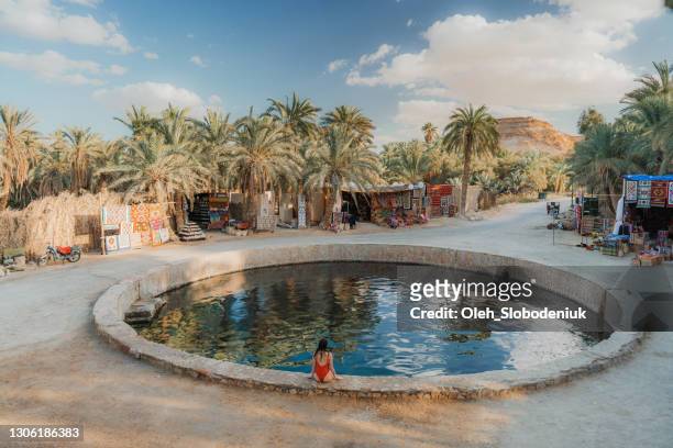 mujer nadando en la primavera de cleopatra en el oasis de siwa - áfrica del norte fotografías e imágenes de stock