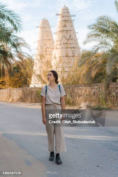 woman walking on the background of  dovecote in siwa oasis - white pigeon stock pictures, royalty-free photos & images
