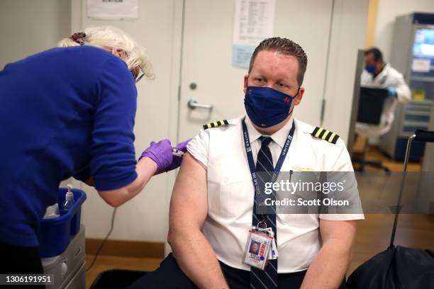 United Airlines pilot Steve Lindland receives a COVID-19 vaccine from RN Sandra Manella at United's onsite clinic at O'Hare International Airport on...