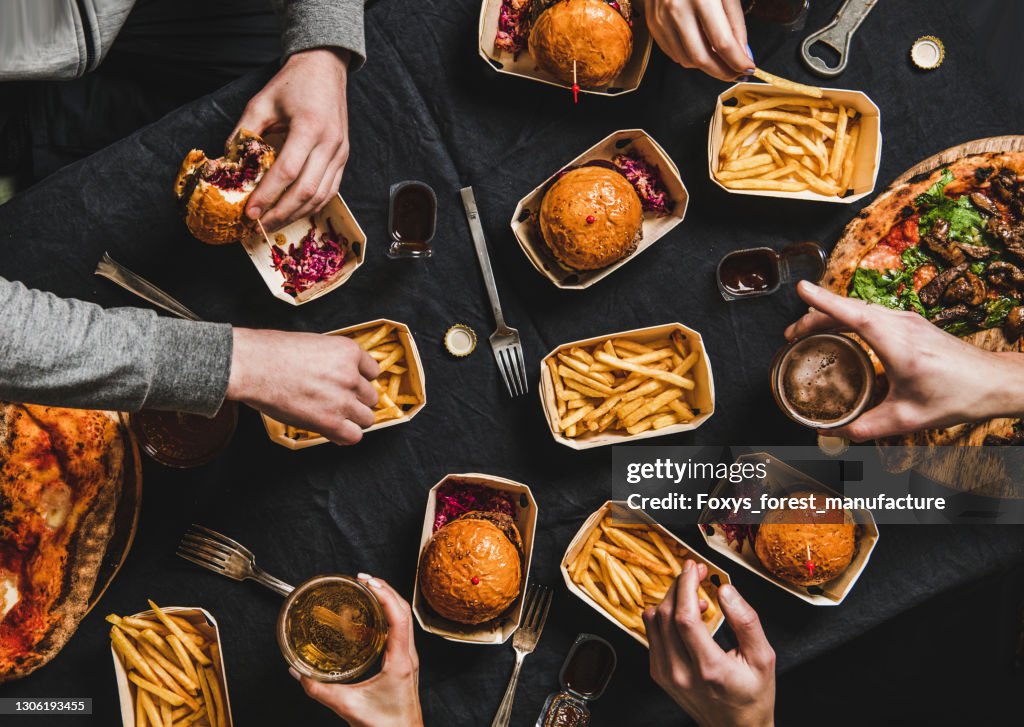 Flat-lay van mensen die voedsel van leveringsdienst thuis eten