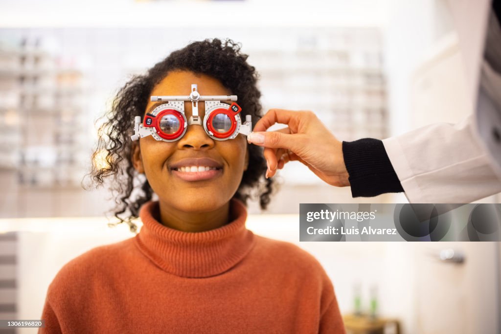 Young woman having eyesight test at optical store