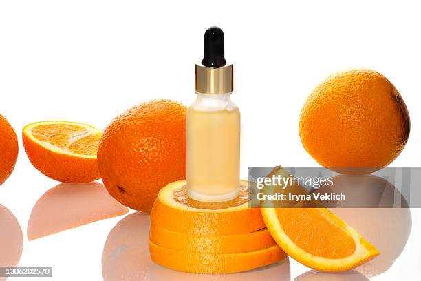 beauty concept of vitamin c serum in cosmetic bottle with dropper and slices of orange fruit on white background. - vitamin c stock-fotos und bilder