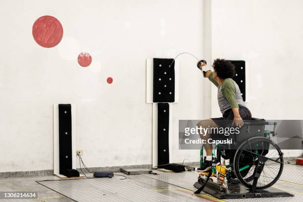 Un atleta masculino de silla de ruedas con patas entrenando estocada en equipos de pared