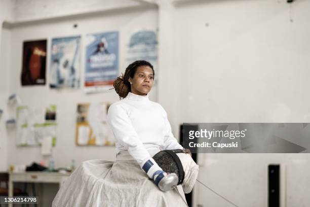 Portret van vrouwelijke rolstoel schermende atleet die masker en zwaard houdt