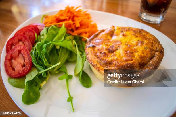 tarta de jamón y queso con ensalada de rúcula, tomate y zanahoria, y vaso de gaseosa. - zanahoria stock pictures, royalty-free photos & images