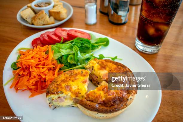 tarta de jamón y queso con ensalada de rúcula, tomate y zanahoria, y vaso de gaseosa. - zanahoria stock pictures, royalty-free photos & images