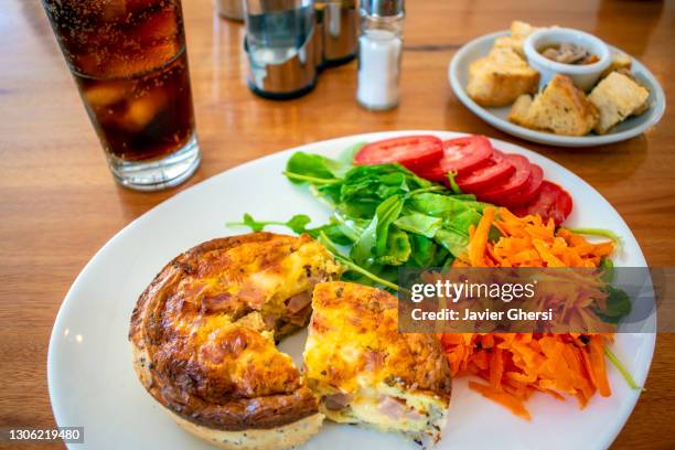 tarta de jamón y queso con ensalada de rúcula, tomate y zanahoria, y vaso de gaseosa. - gaseosa stock pictures, royalty-free photos & images