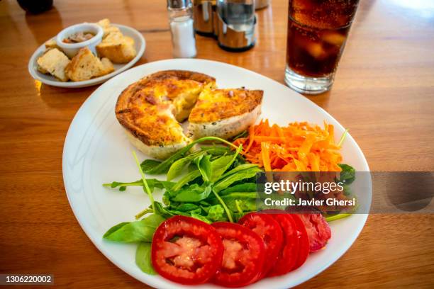 tarta de jamón y queso con ensalada de rúcula, tomate y zanahoria, y vaso de gaseosa. - gaseosa 個照片及圖片檔