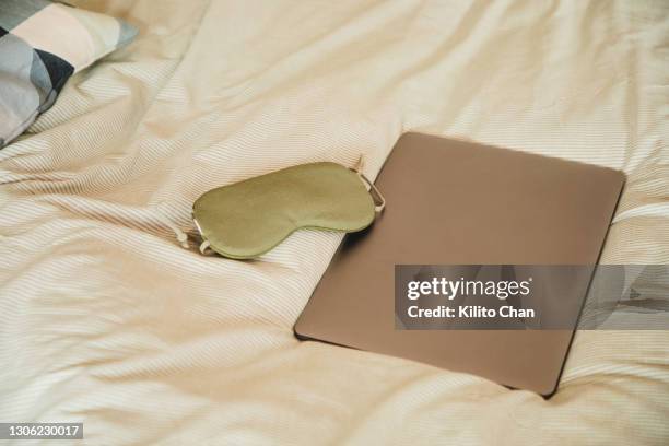 laptop and sleep eye mask on the bed - máscara de olhos imagens e fotografias de stock