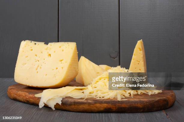 piece of cheese on the board. - cheddar cheese stock pictures, royalty-free photos & images