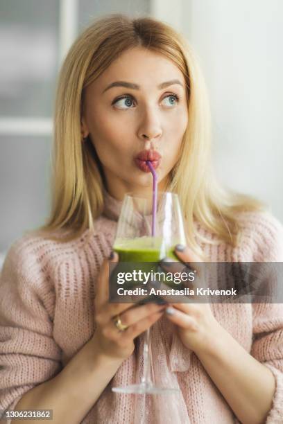 young beautiful woman drinking green juice for detoxing diet. - avocado smoothie stock pictures, royalty-free photos & images