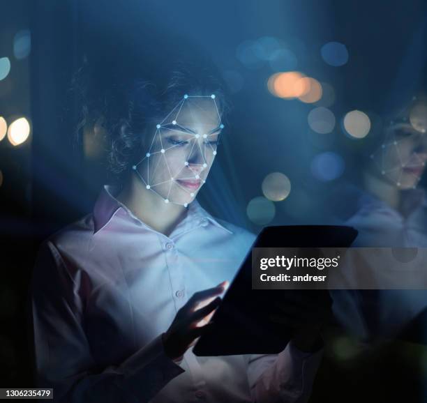 mujer usando tecnología de reconocimiento facial para acceder a su tableta - medical software fotografías e imágenes de stock