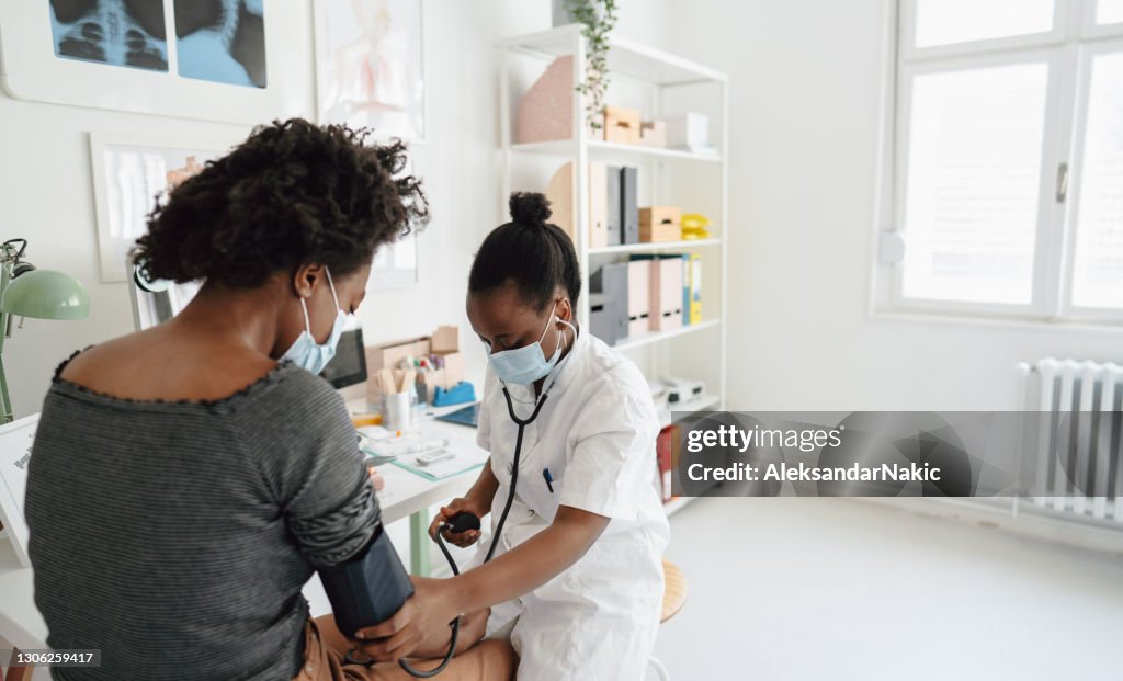 Female doctor checking the patient's blood pressure
