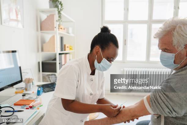 nurse taking a blood sample from a patient - antibody testing imagens e fotografias de stock