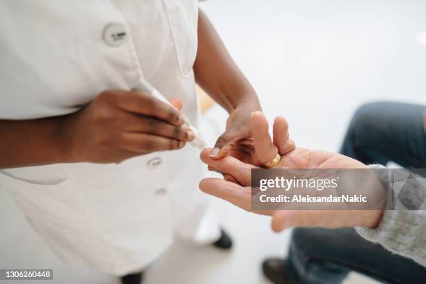 nurse checking patient's glucose levels - antibody testing stock pictures, royalty-free photos & images