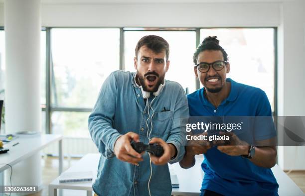 software developers playing video games on a break. - game developer stock pictures, royalty-free photos & images