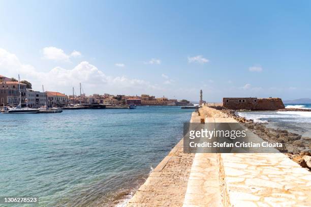 pier to chania lighthouse, crete greece - uferpromenade stock-fotos und bilder