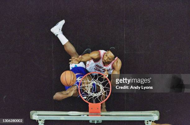 Alonzo Mourning, Center and Power Forward for the Miami Heat and Bryon Russell of the Utah Jazz challenge for the basketball beneath the hoop during...