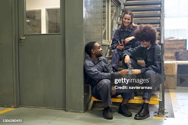 multi-etnische metaalarbeiders die een onderbreking op gieterijvloer nemen - overall stockfoto's en -beelden