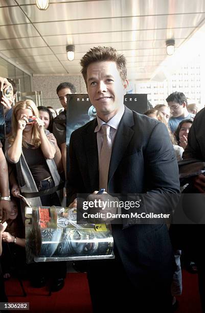 Actor Mark Wahlberg autographs a box with an action figure made in his likeness July 26, 2001 in Boston, Massachusetts at the opening of his new film...