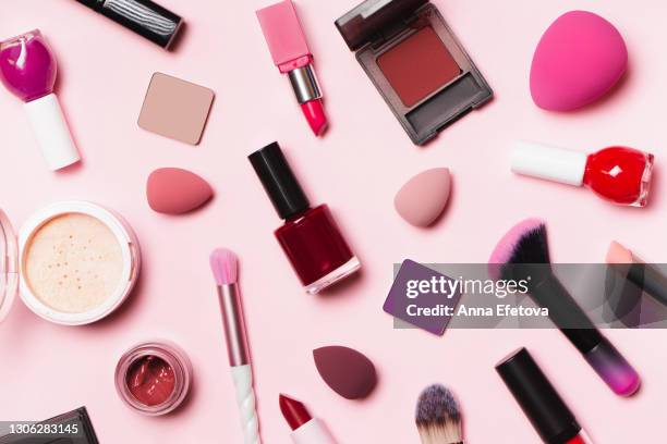 top view of glamour set for makeup application on pink background. soft brushes, lipsticks, face powder, blushes, sponges and nail polish. flat lay style. using decorative cosmetics is a trendy way to brighten up the days after pandemic of the year 2021 - plastic model kit stock pictures, royalty-free photos & images