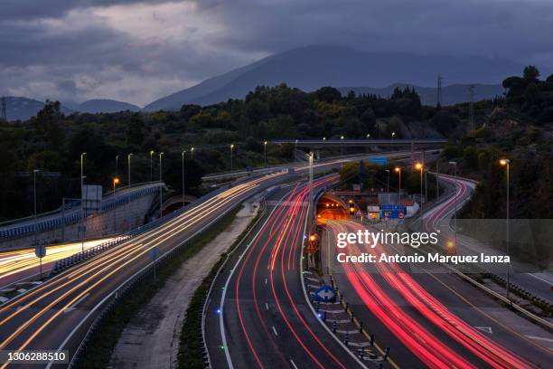 car light trails in a busy motorway on a sunset - car light trails stock pictures, royalty-free photos & images