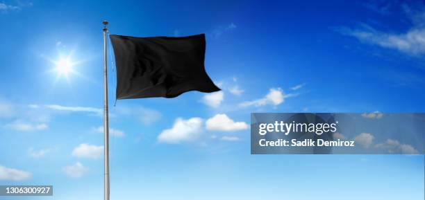 black blank flag on flagpole waving over sunny sky - black flag stock pictures, royalty-free photos & images