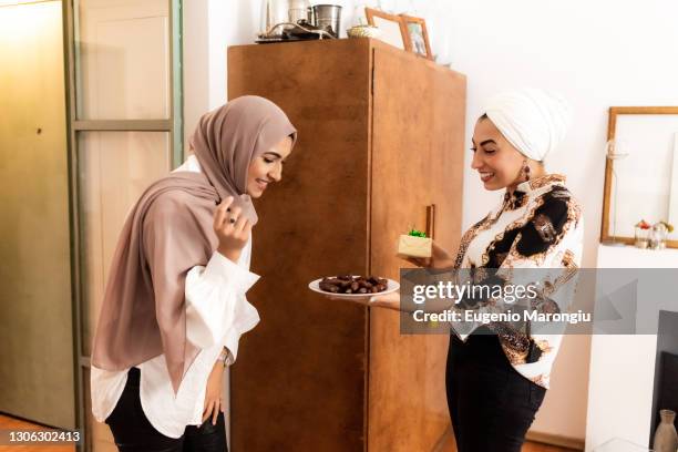 woman offering dates to friend for breaking fast - ramadan giving stockfoto's en -beelden