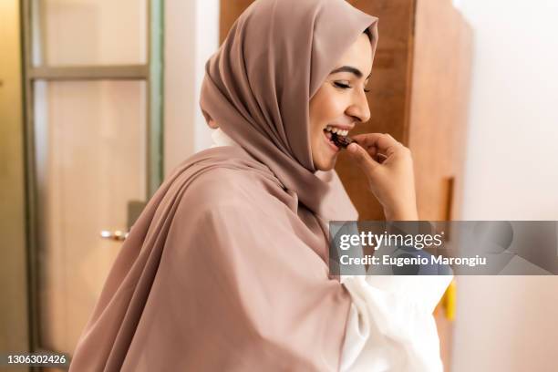 young muslim woman eating date to break fast - date fruit fotografías e imágenes de stock