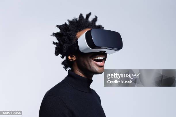 glücklicher junger mann mit virtual-reality-brille - virtual reality stock-fotos und bilder