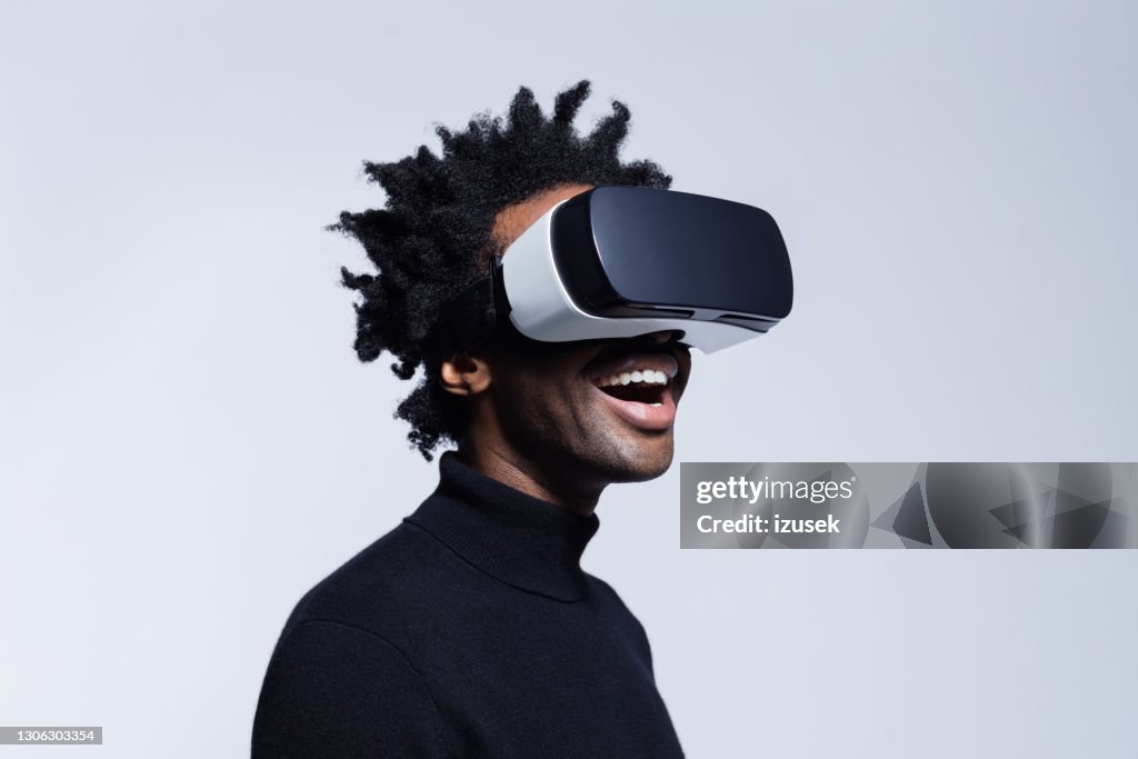 Gelukkige jonge mens die virtual realityglazen met behulp van