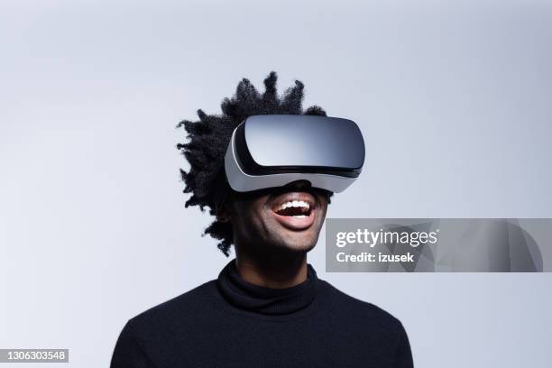 joven feliz usando gafas de realidad virtual - realidad virtual fotografías e imágenes de stock