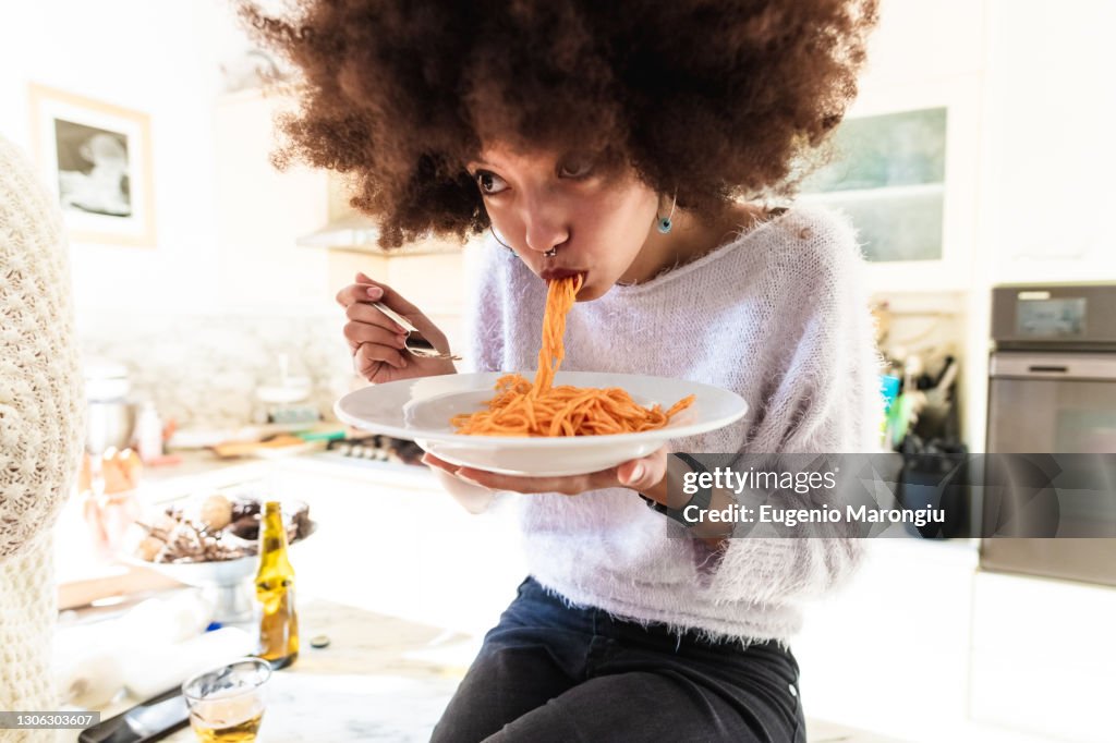 Young woman eating spaghetti