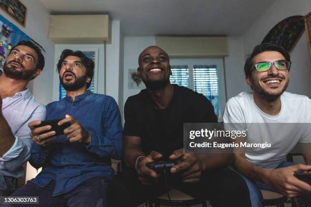 male friends playing computer game - video game stock-fotos und bilder