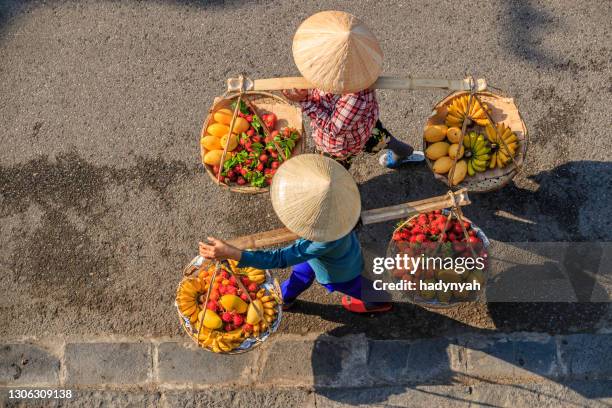 vietnamesische frauen verkaufen tropische früchte, altstadt in hoi an city, vietnam - hoi an vietnam stock-fotos und bilder